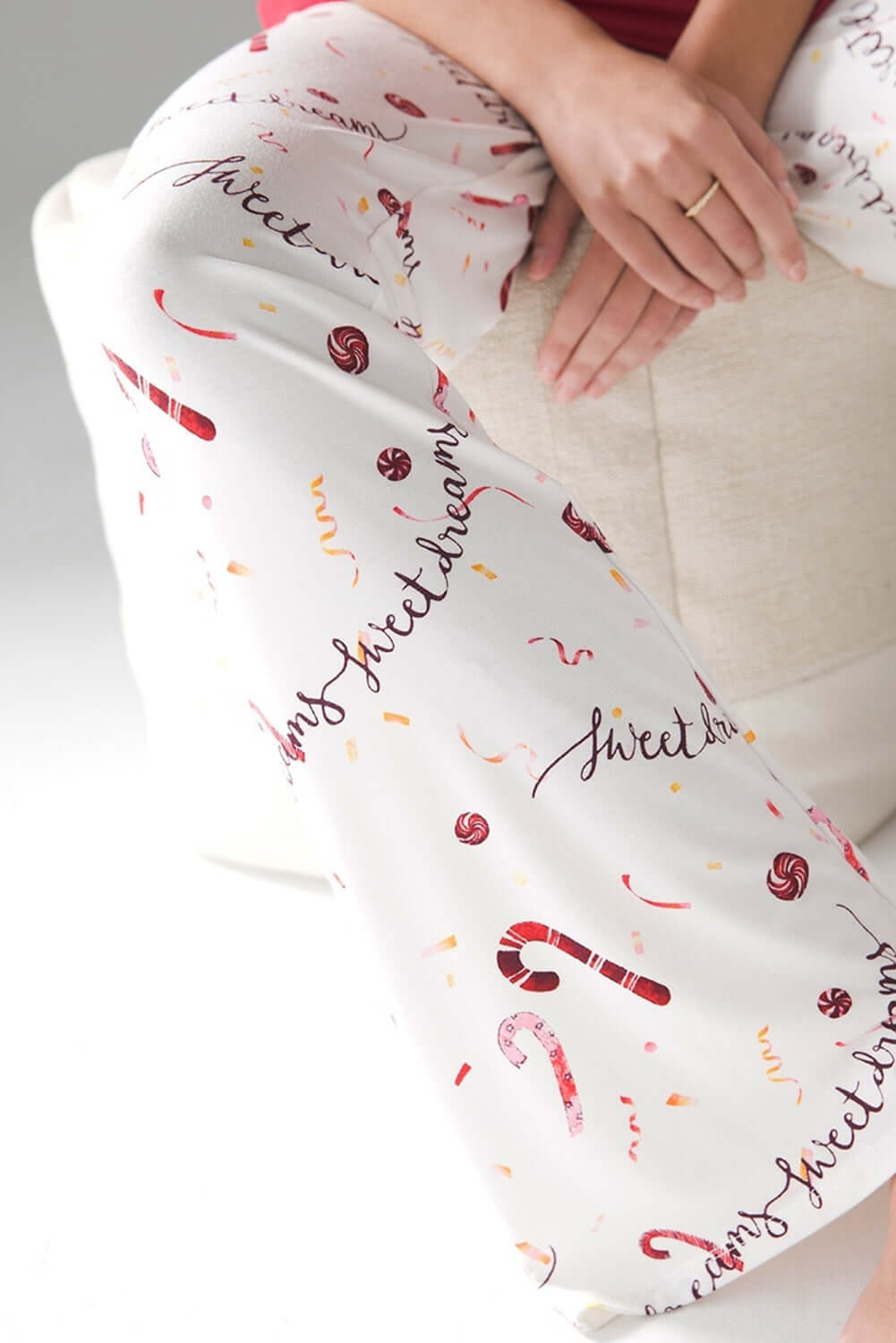 Candy cane patterned pajama pants with holiday design, featuring red and white accents for festive comfort.