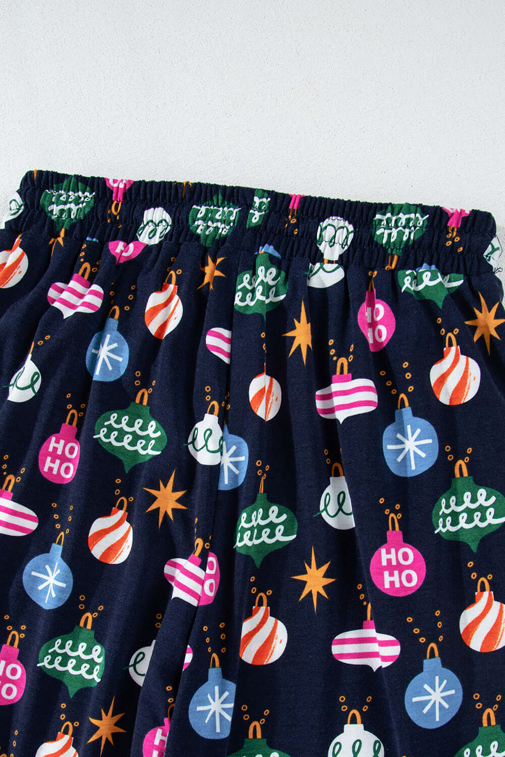 Festive blue pajama pants with colorful holiday decorations and cozy waistband for a playful touch of holiday cheer.