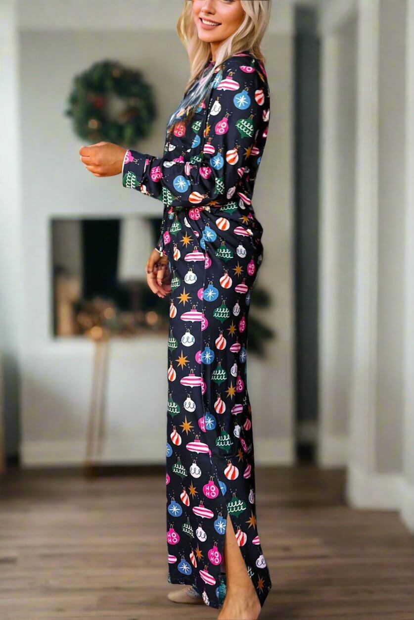 Woman wearing festive holiday pajamas with colorful designs, standing in a cozy living room setting.