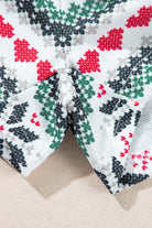 Close-up of festive snowflake print on SLEIGH GIRL SLEIGH PJ Set shorts with red, green, and black patterns on white fabric.