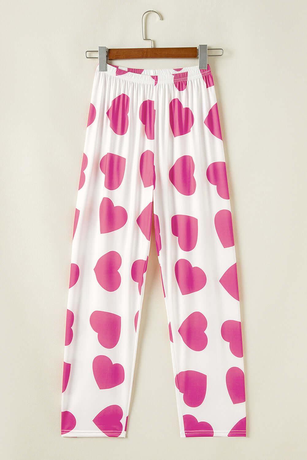 Heart-print lounge pants in white with pink hearts, perfect for cozy lounging and romantic vibes.