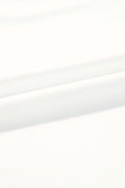 Close-up of soft white fabric, showcasing smooth textures perfect for comfortable clothing.