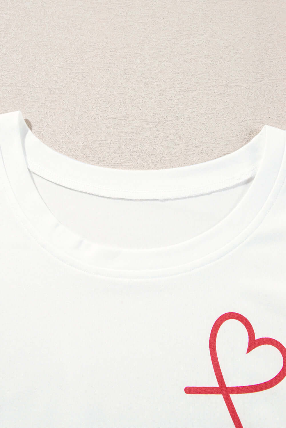 Close-up of a white ruffled tank top with a red heart graphic for Love Language Lounge Set.