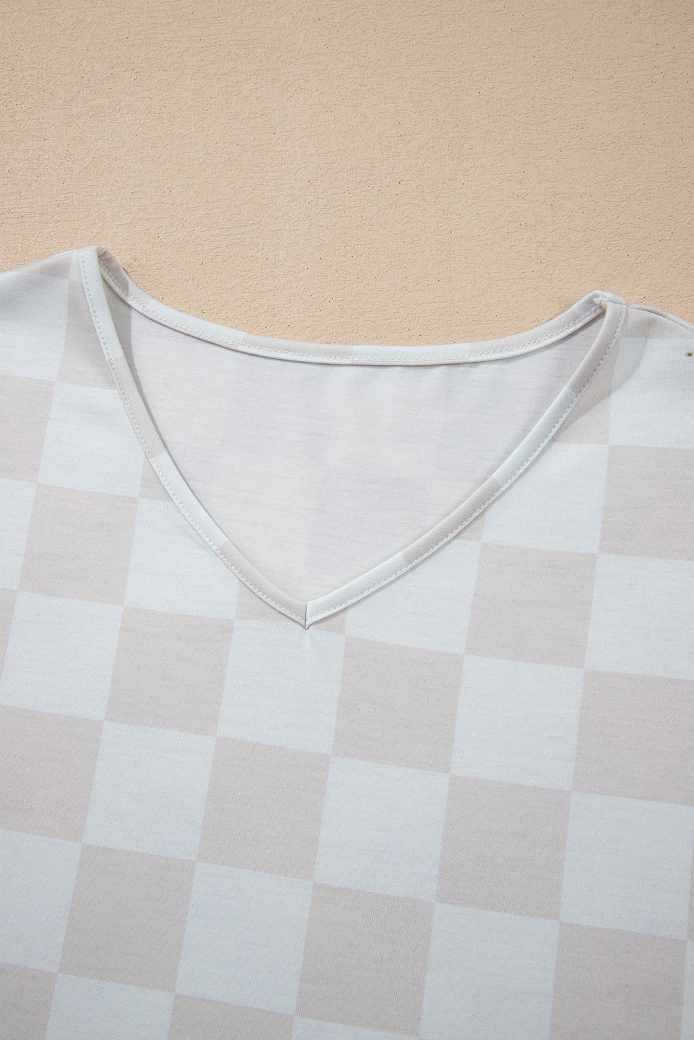 Close-up of a checkered V-neck top from the Weekend Check-In set, featuring soft, neutral tones for effortless style.