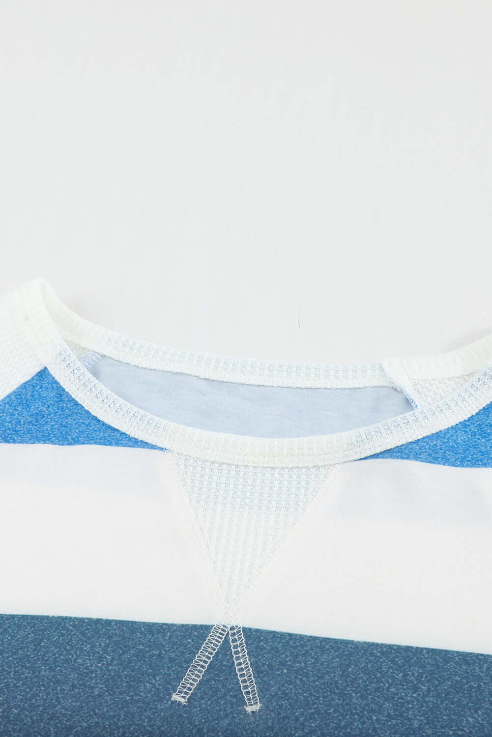 Close-up of MOVING FORWARD color block top from Vivian-Lu, showcasing round neck and blue color details.