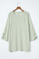 Sage oversized ribbed knit top with roll-tab sleeves and chest pocket, Lines Drawn collection for comfort and style.