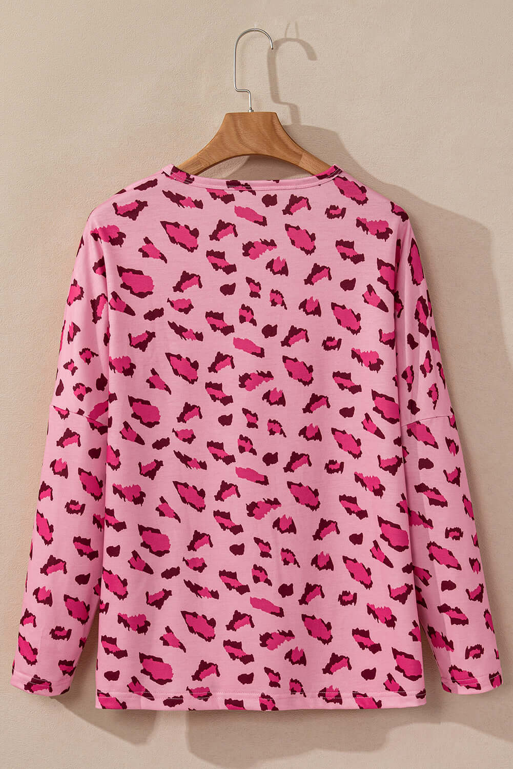 Back view of the PINK PROWL top featuring bold leopard print on lightweight fabric and relaxed fit long sleeves.