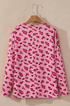 Back view of the PINK PROWL top featuring bold leopard print on lightweight fabric and relaxed fit long sleeves.