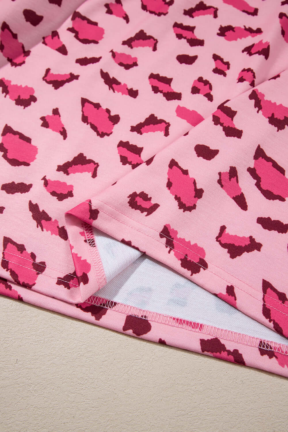 Close-up of pink leopard print fabric highlighting stitching details of the PINK PROWL top by Vivian-Lu.