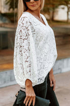 Chic white lace top with V-neck and balloon sleeves, perfect for casual elegance.