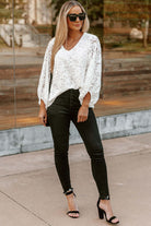 Model wearing the Lace for Days top in white with black skinny jeans and heels, showcasing chic style and elegance.