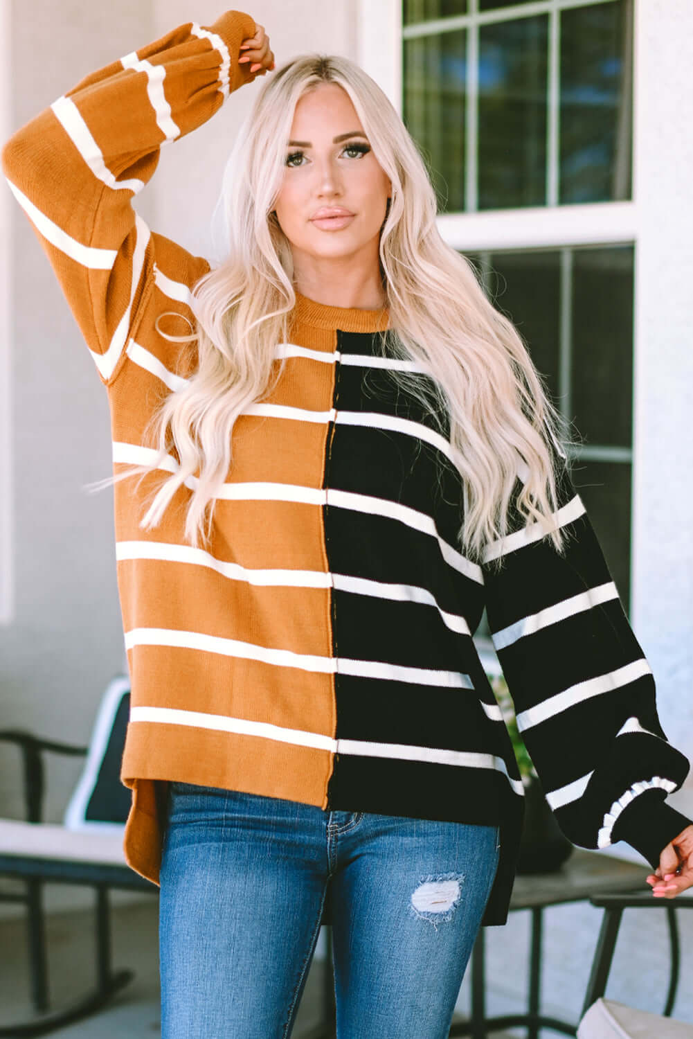 A model wearing the HARVEST SPICE TOP, featuring a striped oversized design in warm autumn colors.