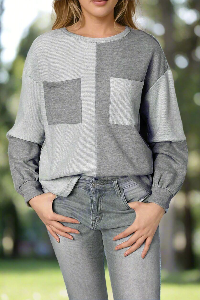 Woman wearing the READ BETWEEN THE LINES top with patchwork design and chest pockets, paired with jeans for a chic casual look.