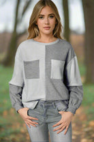 Woman wearing a trendy knit top with patchwork design and chest pockets, perfect for a relaxed chic look, paired with casual jeans.