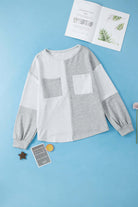 "Vivian-Lu knit top with patchwork design and chest pockets on blue background"