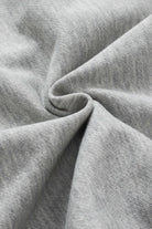 Close-up of the soft gray knit fabric from the READ BETWEEN THE LINES top, highlighting texture and quality for stylish comfort.