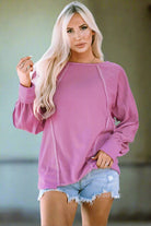 Stylish woman in a pink BEAUTY IN MOTION top by Vivian-Lu, featuring exposed seam detailing and casual shorts.