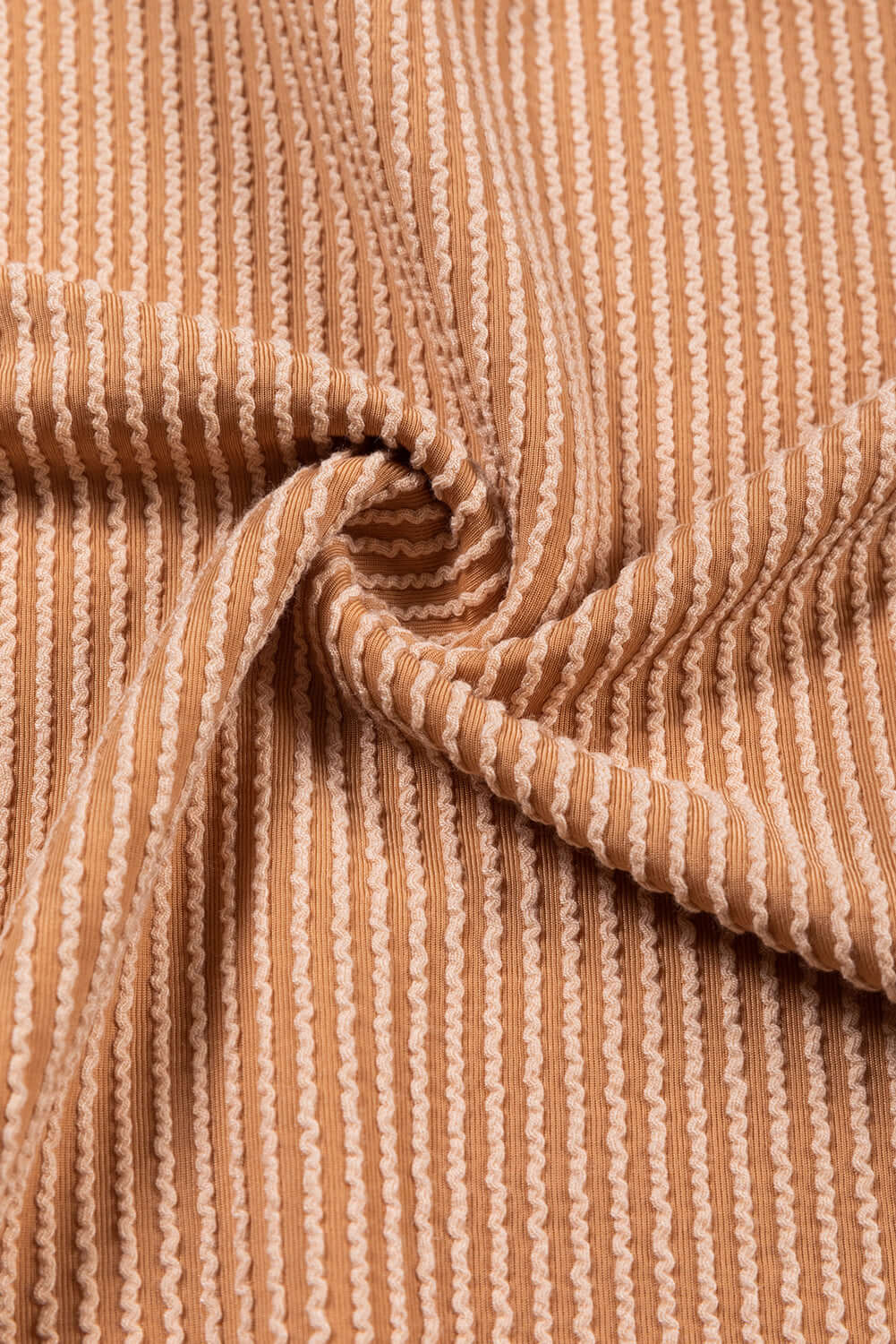 Close-up of taupe and tan ribbed fabric texture, showing vertical stripes on the STANDOUT Color Block Top.