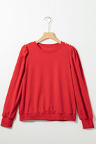 Red top with Bishop sleeves and button-tab detail, perfect for fall and winter fashion.