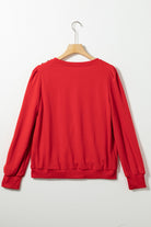 Red Bishop sleeve top with round neck and button-tab detail, perfect for fall and winter fashion.