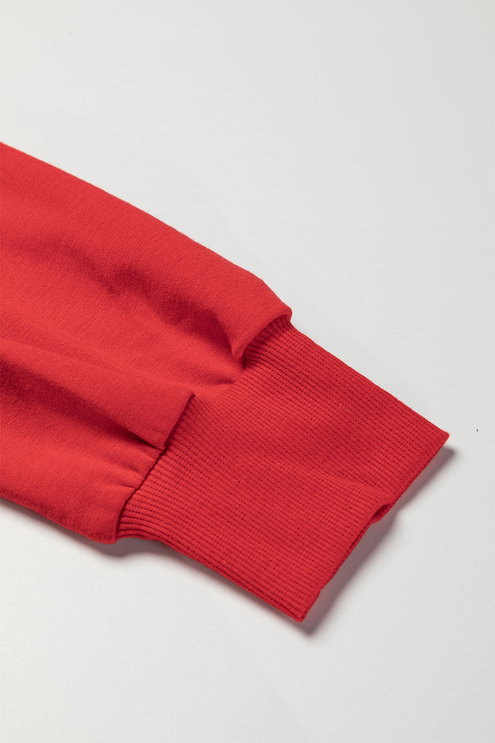 Close-up of the Bishop sleeve with ribbed cuff on the versatile Lady in Red Top, showcasing its elegant stitching and vibrant color.