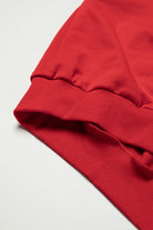 Close-up of red top with ribbed cuffs, showcasing elegant fabric texture for versatile fall and winter fashion.