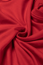 Close-up of elegant red fabric with a soft texture, highlighting the stylish design and rich color of the Lady in Red Top.