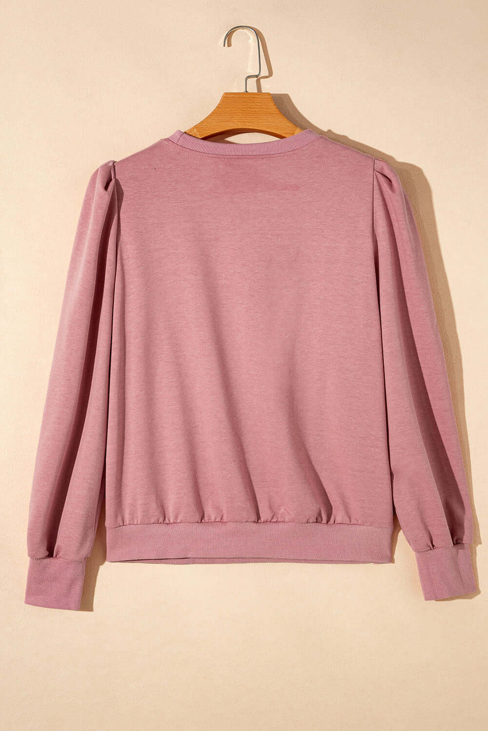 Mauve Rose by Any Other Name Top with Bishop sleeves and round neck on hanger, back view.