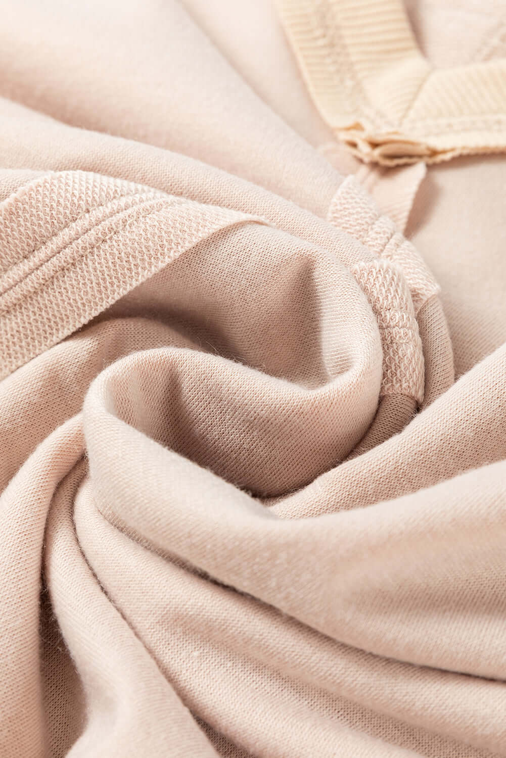 Close-up of beige fabric with exposed seam detailing from the ON MY MIND Top by Vivian-Lu.