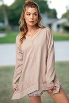 Woman wearing ON MY MIND Top by Vivian-Lu, featuring v-neck, dropped shoulders, and side slits with chic seam detailing in a casual outdoor setting.