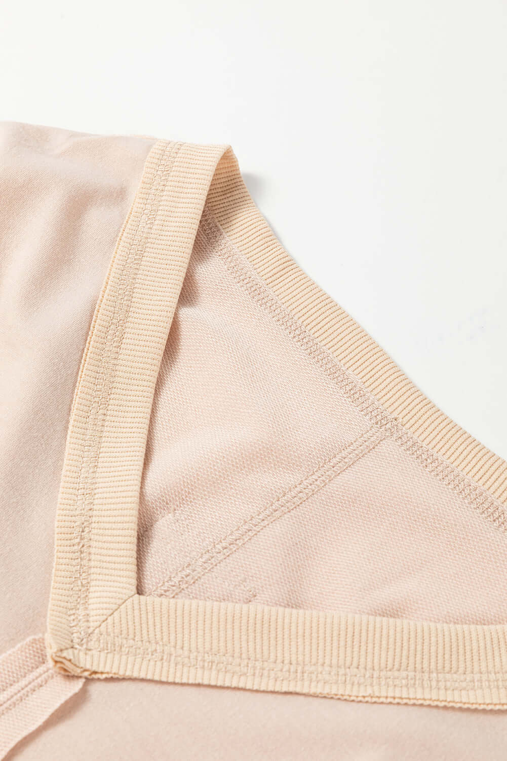 Close-up of ON MY MIND Top by Vivian-Lu showing v-neck and exposed seam detail in light beige fabric.