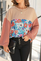 Woman wearing Boho Beauty Top by Vivian-Lu featuring floral color block design with ribbed sleeves, paired with black pants and a clutch.