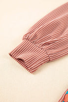 Close-up of ribbed sleeve on BOHO BEAUTY Top by Vivian-Lu featuring contrast color block and floral print.