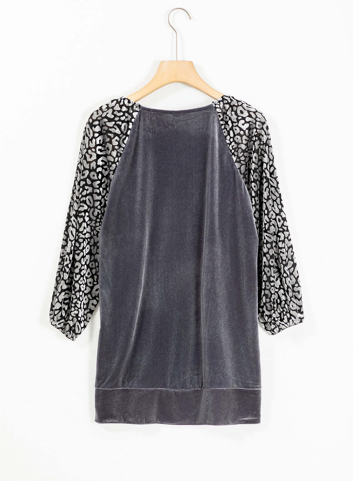 Velvet leopard print top with raglan sleeves and lantern half-length in dark fabric on hanger.