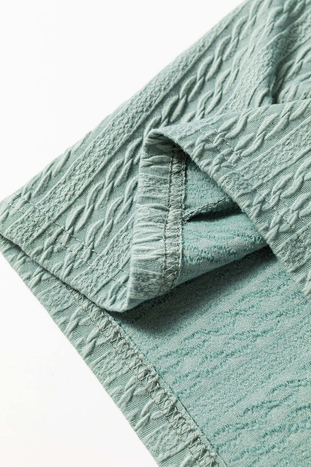 Textured minty sage green fabric of the Found You top showcasing its stylish and cozy design.