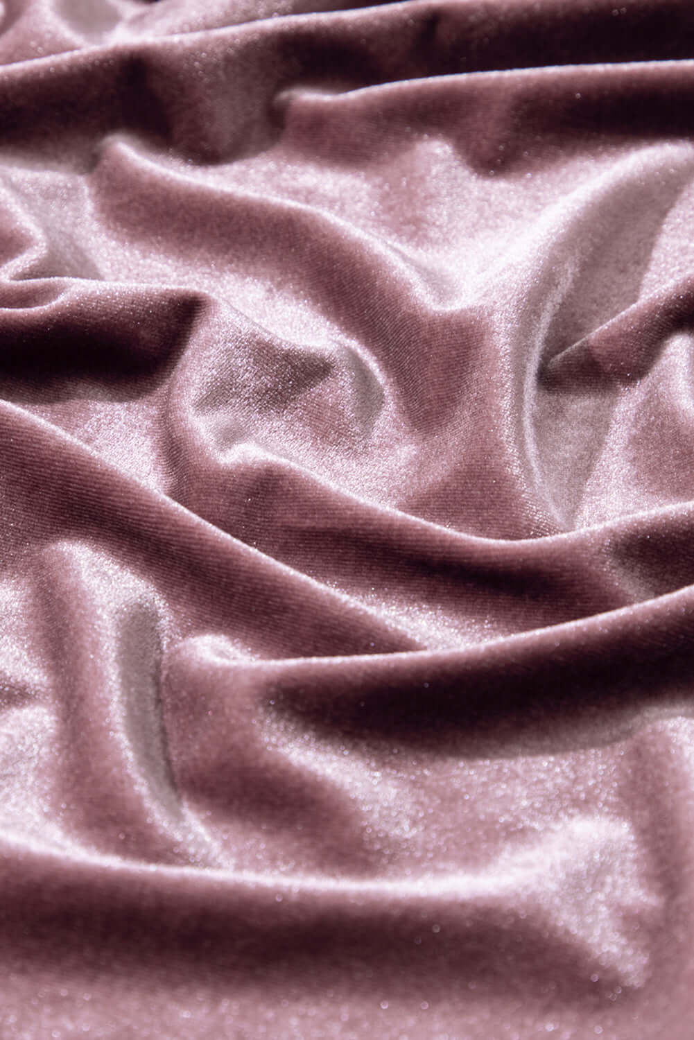 Luxurious soft lilac velvet fabric with elegant folds and a shimmering texture, perfect for stylish blouses and garments.