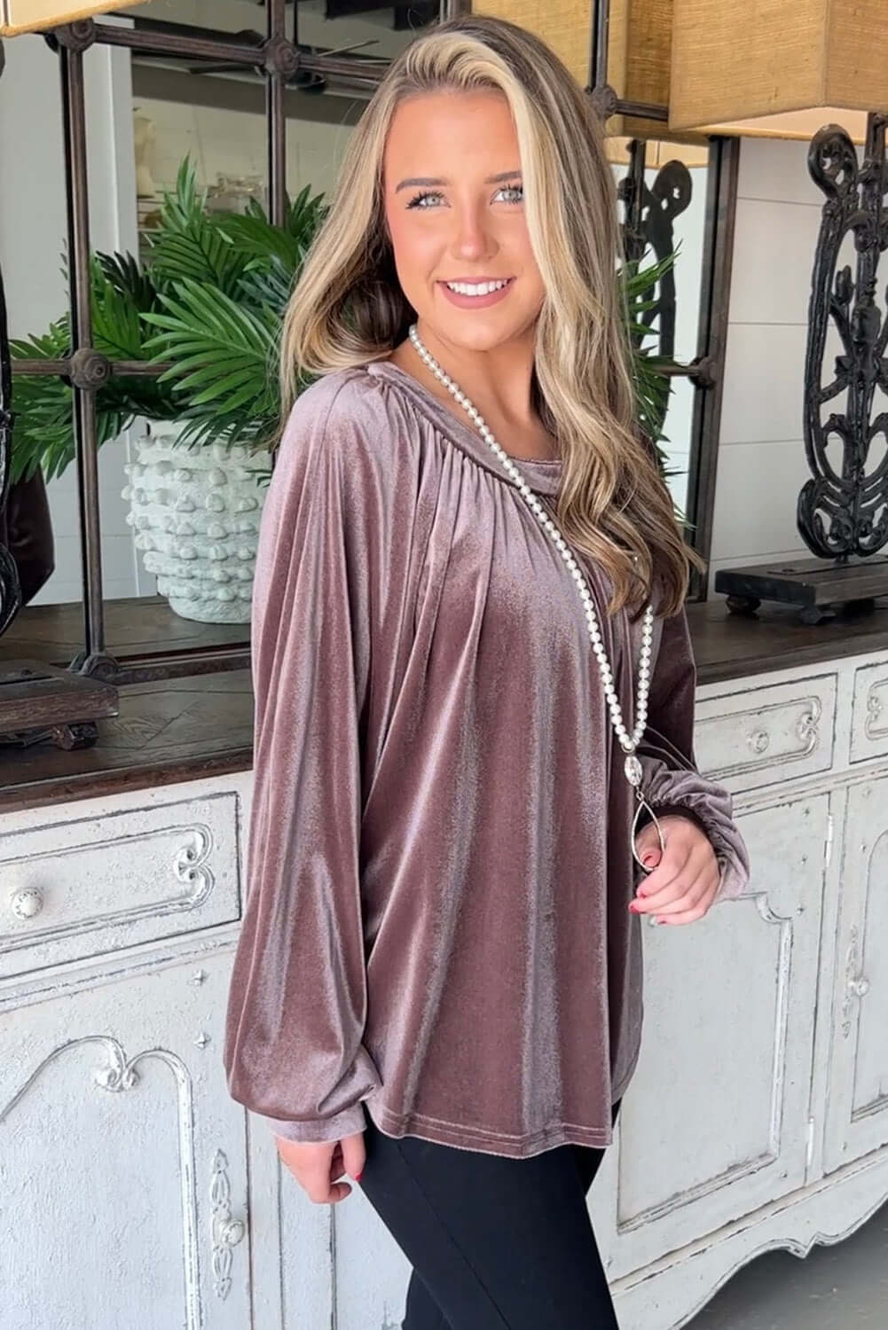 Woman wearing Lilac Luxe Top in soft velvet with long sleeves and round neck, styled with a pearl necklace.