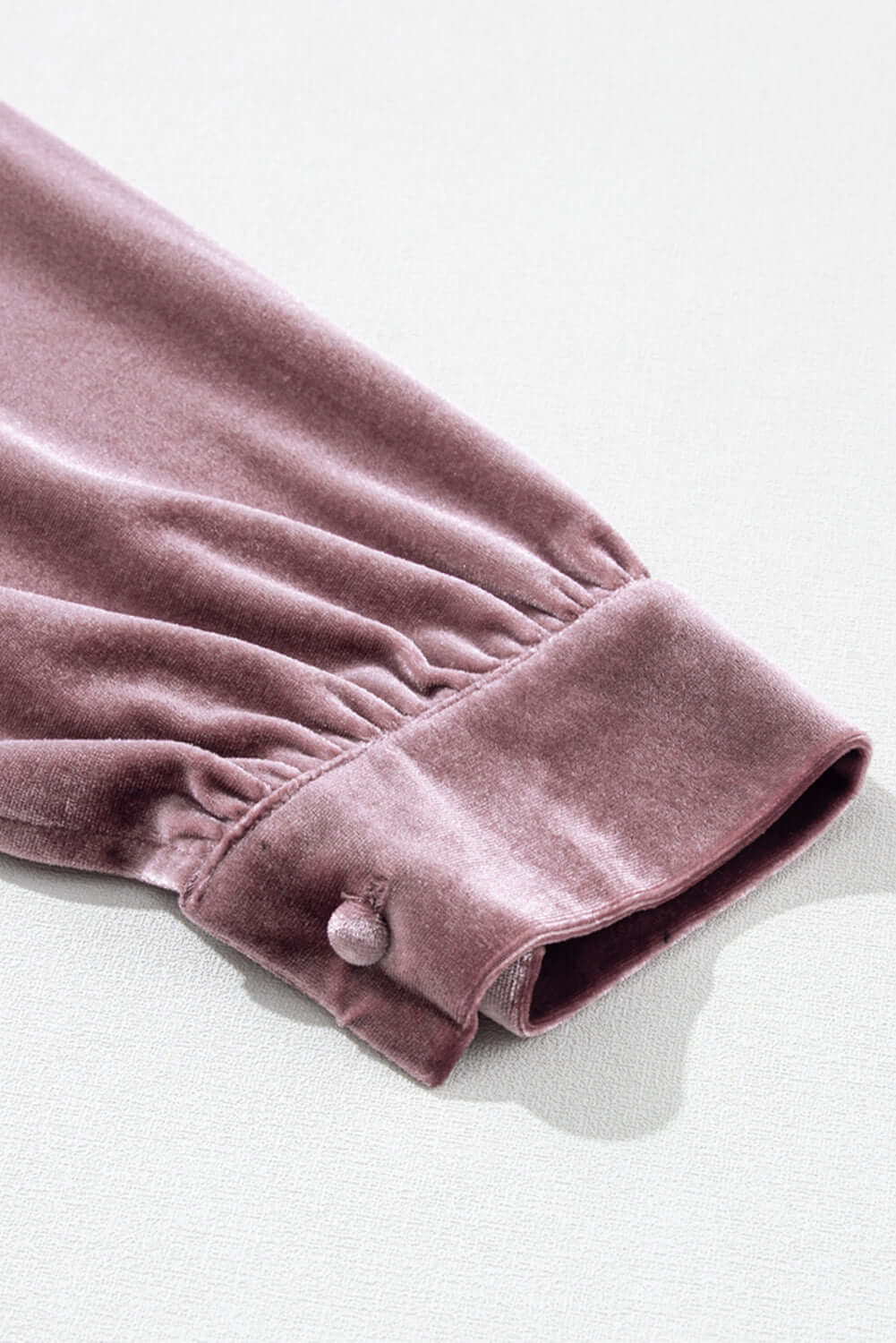 Close-up of Lilac Luxe Top velvet sleeve with button detail, showcasing the luxurious fabric and elegant design.