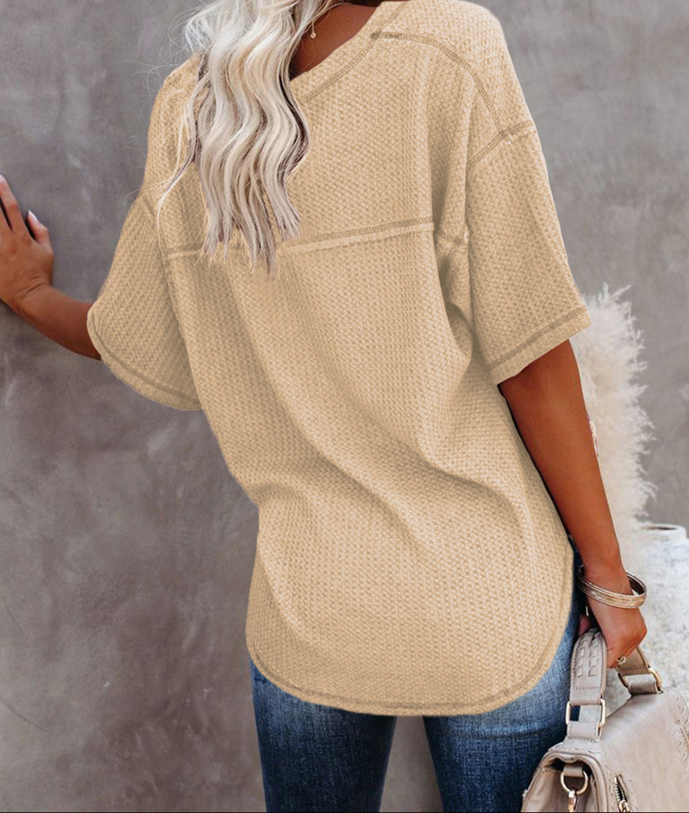 Back view of a woman wearing a cream textured knit top, showcasing a relaxed fit and dropped shoulders.
