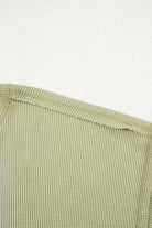 Close-up of the texture and neckline of the Carefree Mode Top in sage green, showcasing its soft knit fabric.