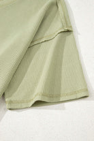 Textured sage knit fabric close-up, showcasing breathable and relaxed summer style.