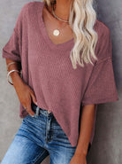 Stylish woman wearing a rosewood Carefree Mode Top with v-neck, relaxed fit, paired with blue jeans.