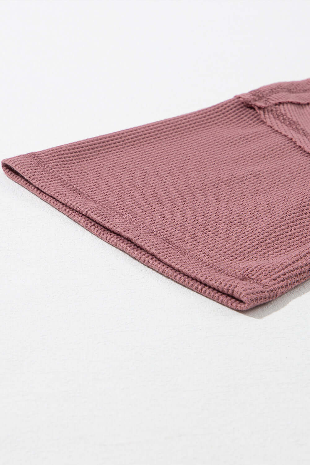 Close-up of Carefree Mode Top in rosewood color, showcasing textured knit fabric and relaxed fit design.