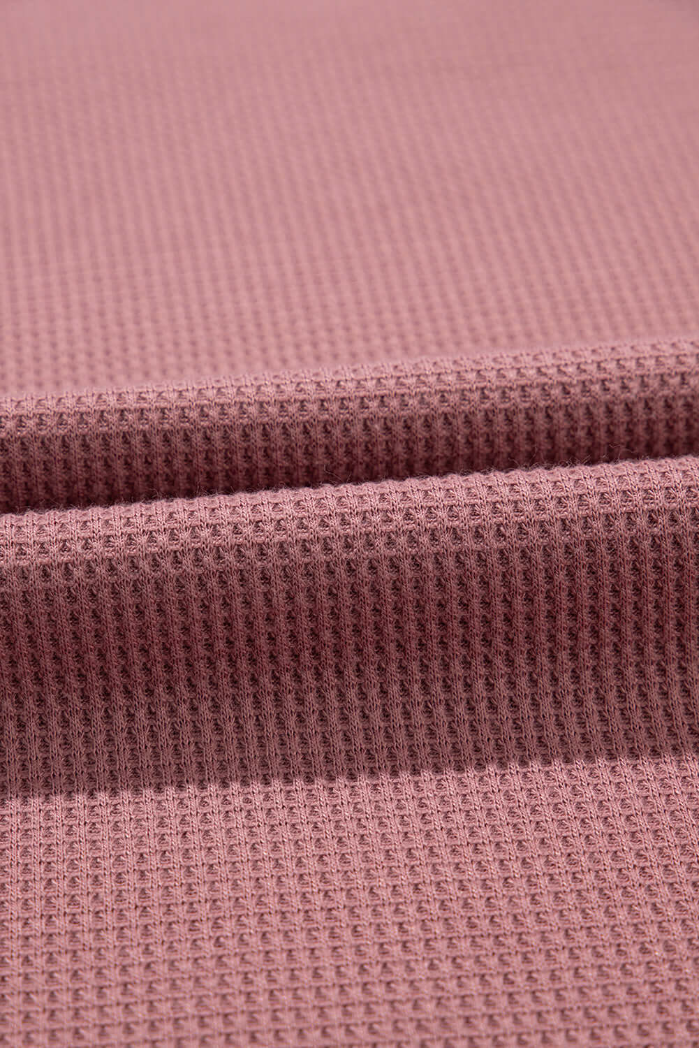 Textured rosewood fabric showcasing soft, breathable knit perfect for relaxed summer clothing.