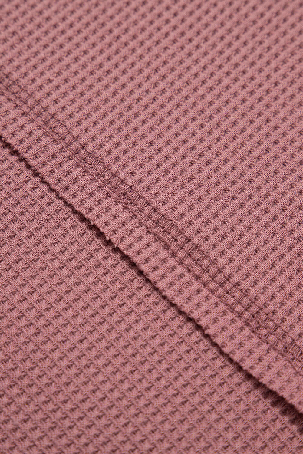 Close-up of the textured rosewood fabric of the Carefree Mode Top, highlighting its soft, breathable knit.