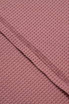 Close-up of the textured rosewood fabric of the Carefree Mode Top, highlighting its soft, breathable knit.