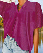 Raspberry Gemtone Top in velvet with pleated texture, short bubble sleeves, and V-neckline, paired with denim shorts.