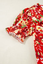 Close-up of Tropical Tango red floral bubble sleeve blouse showcasing vibrant design and elastic cuff details.