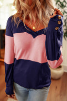 Woman wearing the BETTER DAYS Top by Vivian-Lu with pink and navy color blocking and button details on the sleeves.