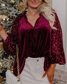 model wearing SEQUIN SIREN velvet top with ruffled neckline and sequined sleeves, perfect for holiday occasions.